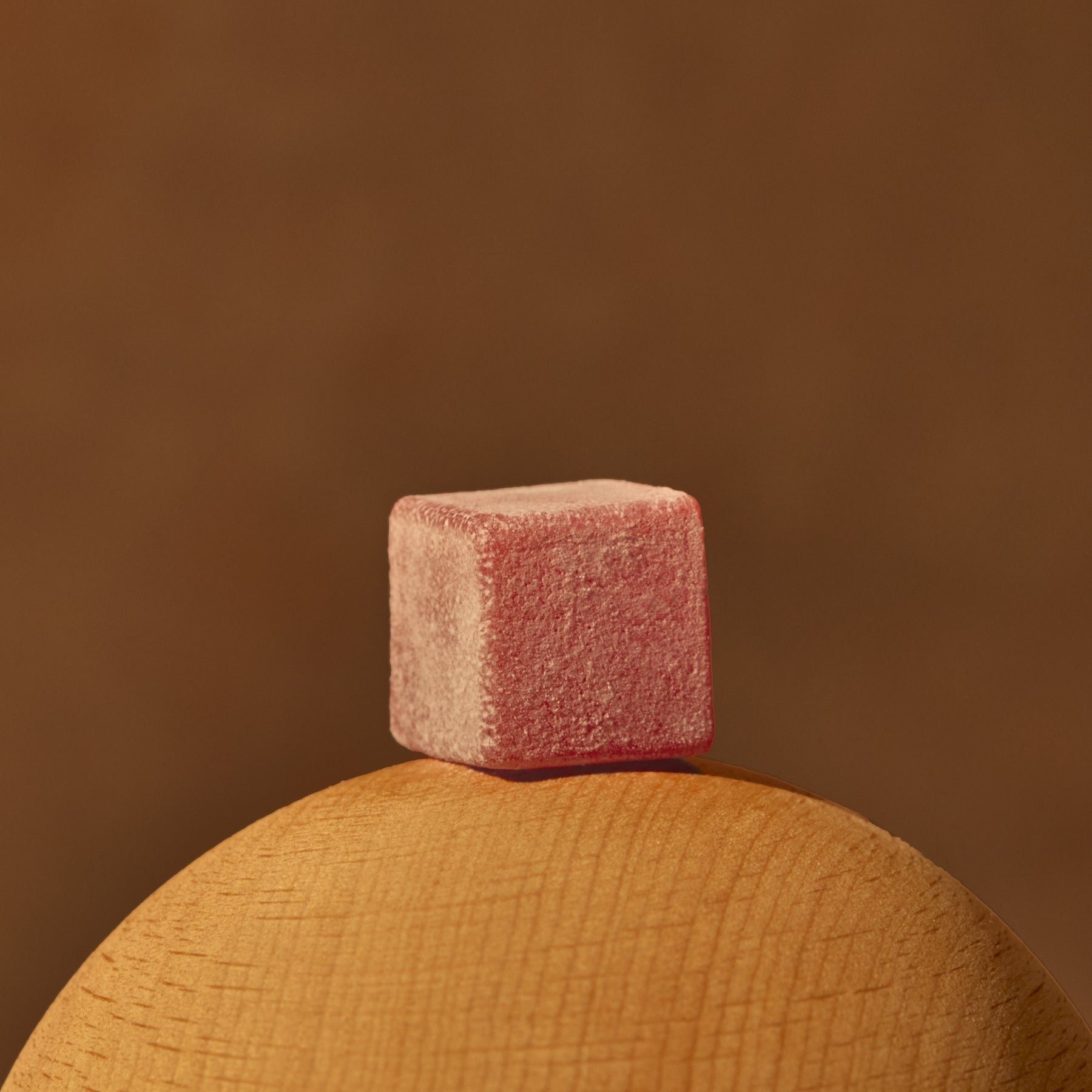 A Flow State gummy, up close, on the wooden lid of the jar